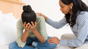Mom trying to comfort her upset teen daughter